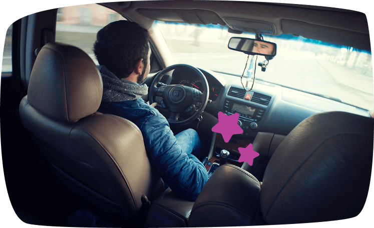 Hombre conduciendo un coche desde el interior, simbolizando el trabajo de aparcacoches como opción para ganar dinero extra los fines de semana.