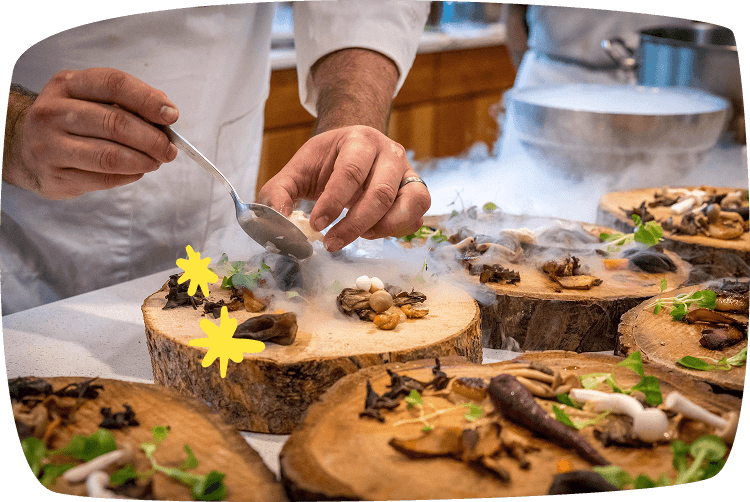 Chef profesional decorando un plato con ingredientes naturales, representando el trabajo de chef a domicilio para eventos.