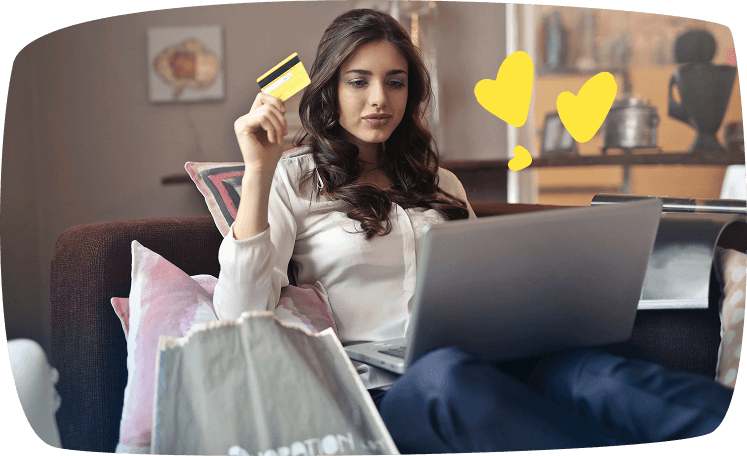 Mujer joven comprando online con tarjeta de crédito en la mano, como ejemplo de cliente misterioso evaluando tiendas.