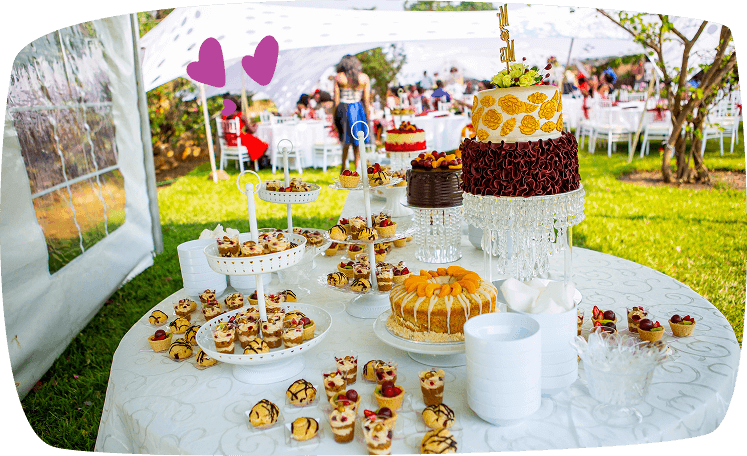 Mesa decorada con pasteles y postres en una celebración al aire libre, ideal para eventos infantiles o bodas.