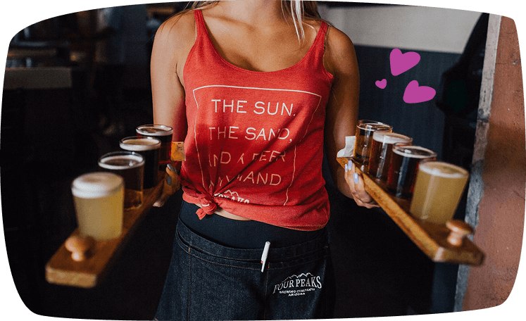 Camarera joven sirviendo bebidas artesanales en una cervecería, trabajando con energía y estilo informal.