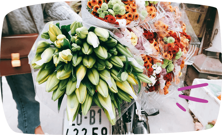 Bicicleta decorada con ramos de flores frescas listas para la venta en un mercado callejero.