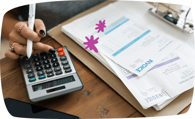 Persona usando una calculadora junto a facturas e informes financieros, organizando su presupuesto mensual.