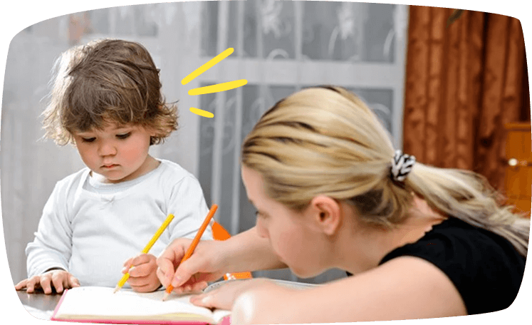 Niñera ayudando a un niño pequeño a dibujar, representando la atención personalizada y educativa.