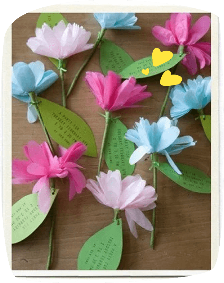 Flores de papel hechas a mano con hojas que contienen la invitación a la fiesta de cumpleaños.