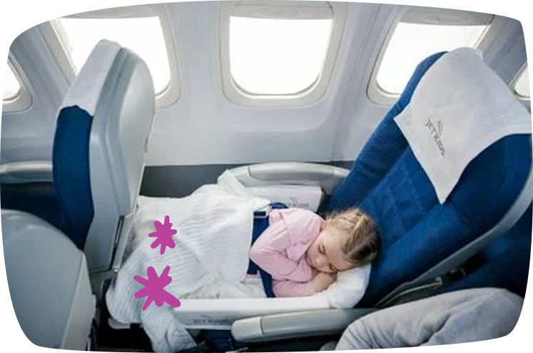 Niña durmiendo plácidamente en un avión gracias al invento JetKids que convierte el asiento en cama