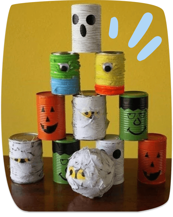 Latas recicladas pintadas como monstruos y fantasmas para un juego de puntería en una fiesta de Halloween.