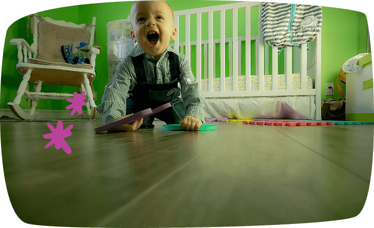 Bebé gateando sobre el suelo en una habitación infantil con cuna y alfombra