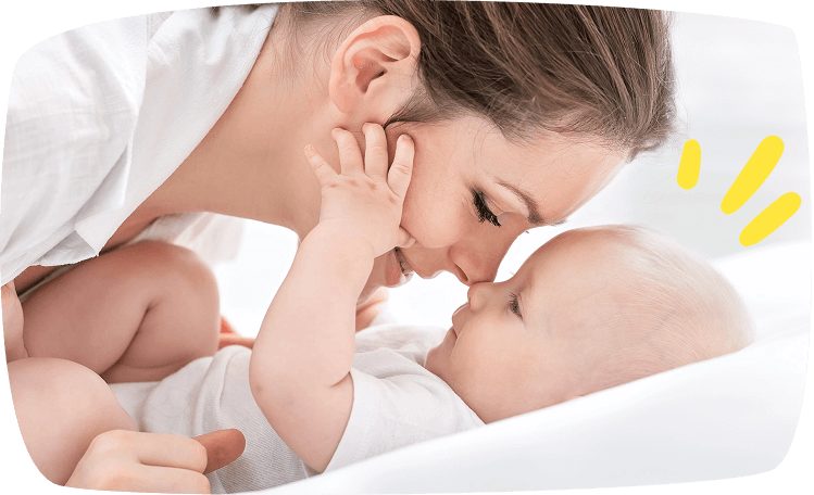 Madre tocando cariñosamente el rostro de su bebé mientras se miran.