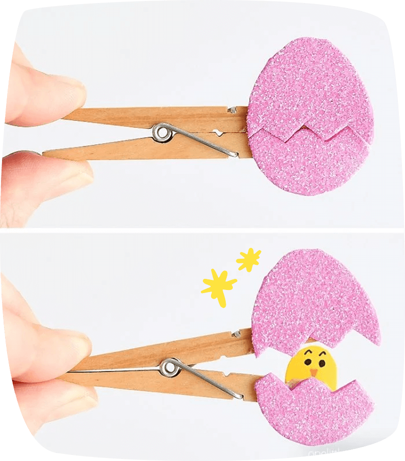 "Pinza de madera con un huevo de Pascua rosa brillante que se abre para mostrar un pollito sonriente dentro."