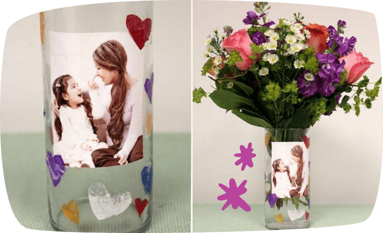 Jarrón decorado con foto y corazones, lleno de flores frescas.