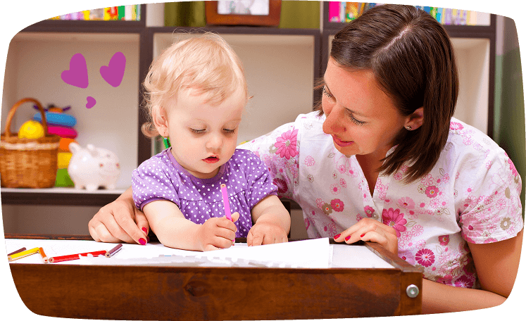 Niñera ayudando a una niña pequeña a dibujar con lápices de colores.