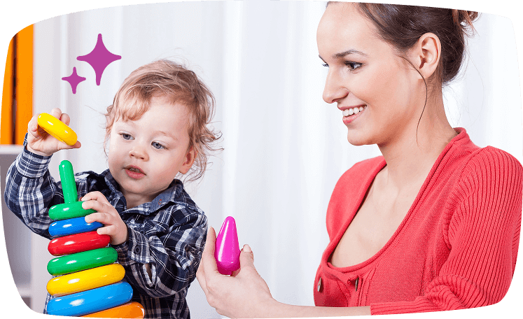 Niño pequeño jugando con aros de colores junto a una niñera, mostrando actividades educativas y lúdicas.