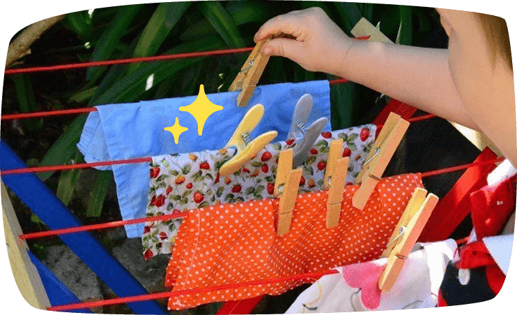 Niño tendiendo ropa con pinzas como actividad Montessori de autonomía