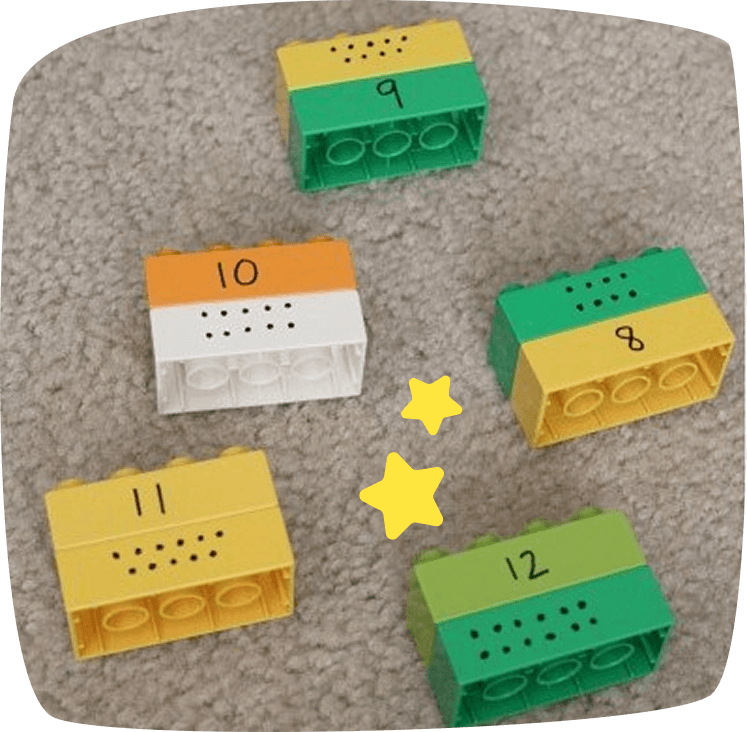 Piezas de construcción LEGO etiquetadas con números y puntos, utilizadas en un juego para enseñar a contar a niños de preescolar.