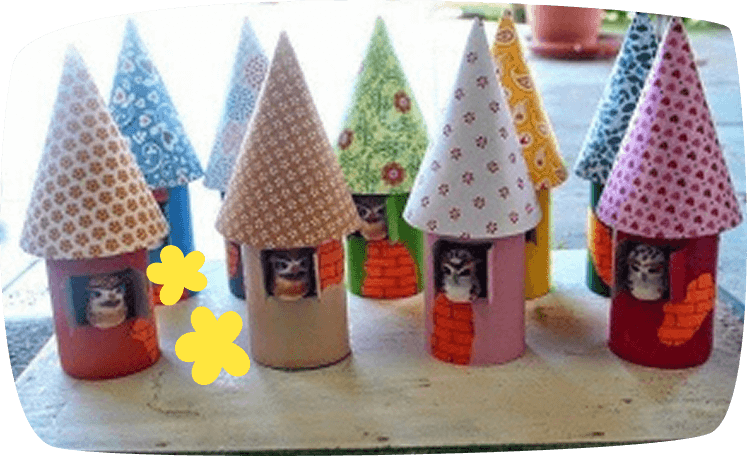 Casitas de pájaros hechas con rollos de papel higiénico y techos de cartulina decorada.