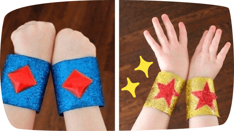 Brazaletes de superhéroes hechos con rollos de papel, decorados con purpurina y formas de estrellas.