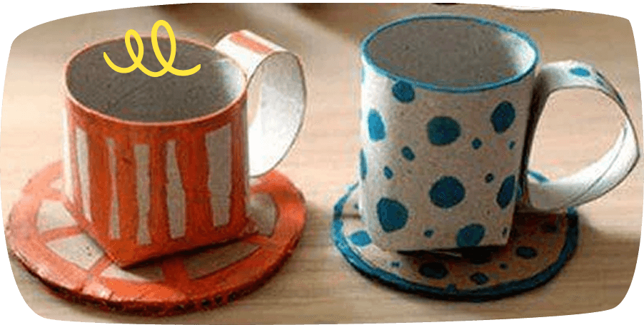 Tazas con platos hechas con rollos de cartón reciclado, decoradas con pintura de colores.