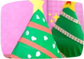Árboles de Navidad elaborados con cartulina verde decorados con estrellas y cintas rojas.
