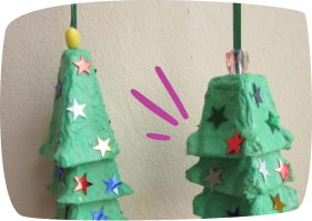 Manualidad de árboles navideños realizados con cartones de huevo y decorados con estrellas de colores.
