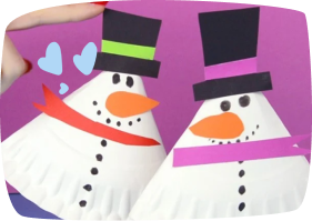 Muñecos de nieve hechos con platos de papel y cartulina de colores para sombreros y bufandas, una manualidad infantil navideña.