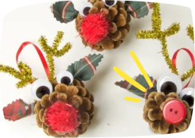 Divertidos renos navideños elaborados con piñas, pompones rojos y ojos móviles para colgar en el árbol.