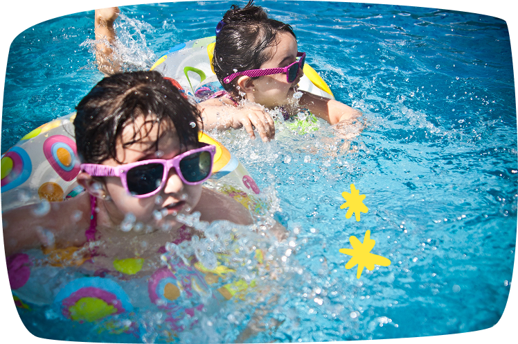 Niños nadando con flotadores y gafas de sol, disfrutando del agua tras dejar el pañal.
