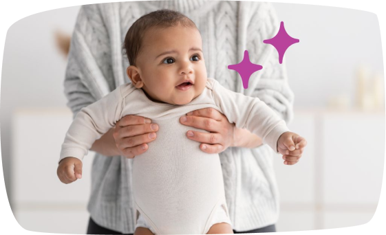 Bebé de pie sostenido por un adulto desde atrás